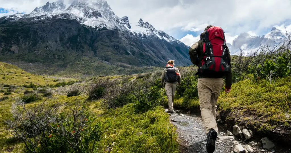 Stock photo of people hiking on an outdoor trail, with a mountain in the distance.