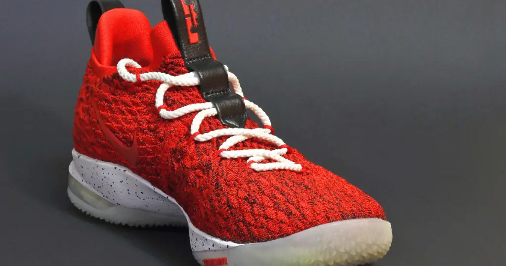 Photo of a red basketball shoe with white laces and white sole.