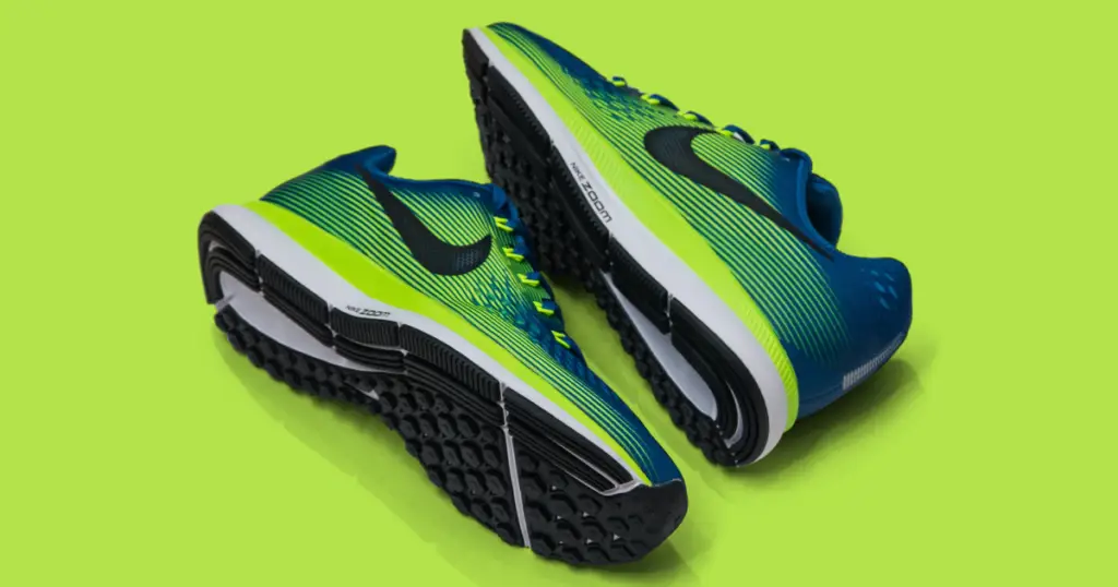 Art photo of lime green and blue Nike sneakers against a lime-green background.