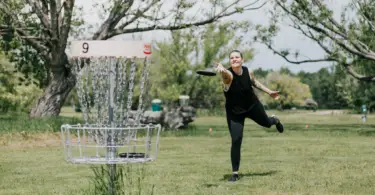 Stock photo of a woman outside playing disc golf.