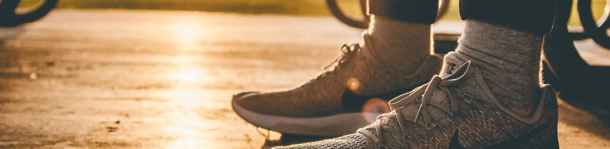 Stock photo of a person's feet in sneakers on an outdoor road.