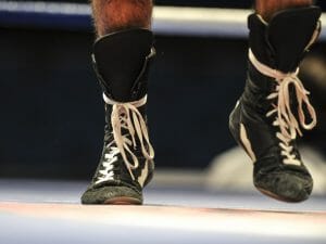 Close up action shot of wrestler walking forward with laced up boots.