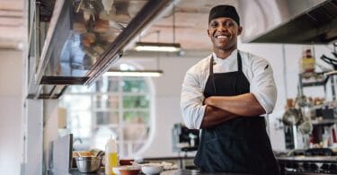 Chef in his kitchen with crossed arms and smiling