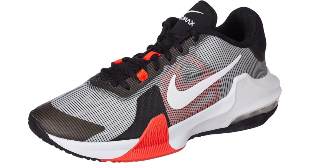 Photo of white shoe with black detailing and black striping (thin, makes it appear gray), with white sole and orange detail on front sole and laces. Airmax logo is on the shoe tongue.