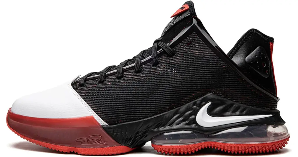 Black Lebron 19 Low basketball shoe with white toe and red heel, and white Nike swoosh on the back side of the heel.
