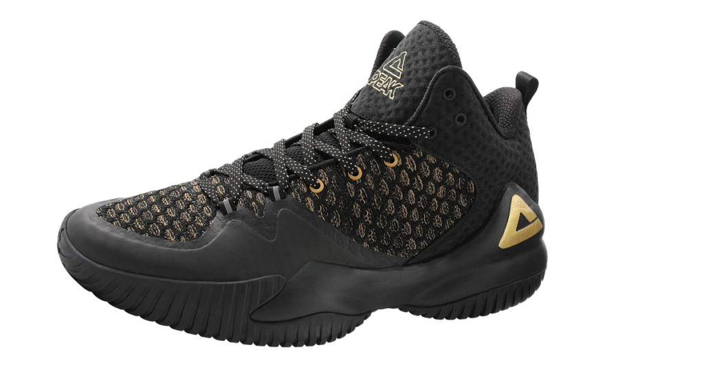 A black sneaker with light gold fish scale design, black sole, black and white laces, and the PEAK triangle logo in gold on the side of the heel sole.